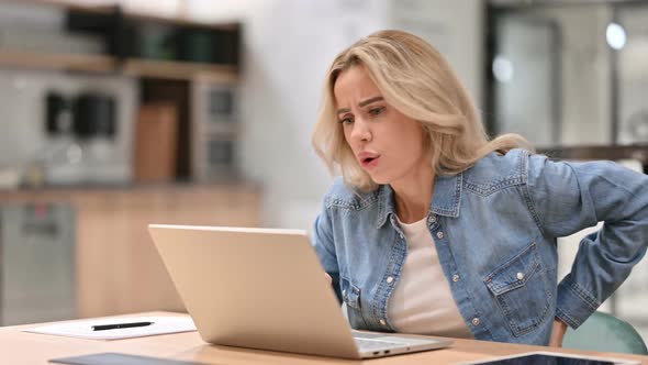 Young Woman with Back Pain Using Laptop at Work alt