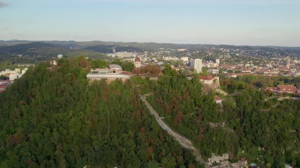 Aerial view over Uhrturm clock tower on Graz's Schloßberg dolomite woodland hilltop revealing Graz c alt