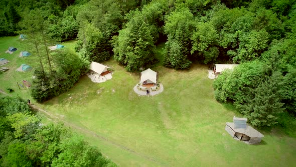 Aerial view of couple standing in front of sitting area at a camping site. alt