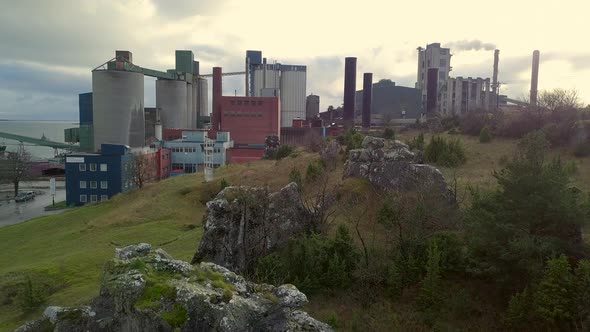 Drone shot of rocks in front of industry buildings