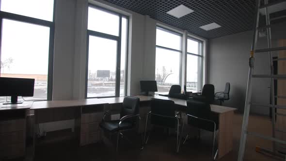 Wooden Desks with Chairs and Computers in Repaired Office alt