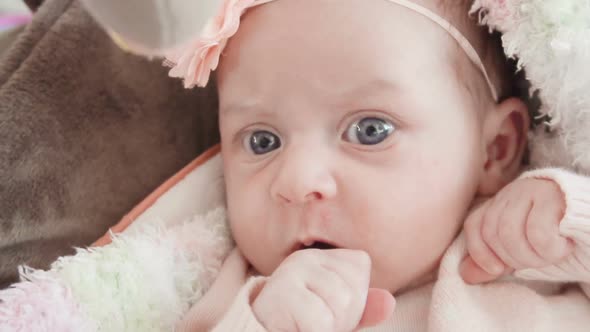 Slow motion. Infant baby girl in pink and white stripes outfit. alt