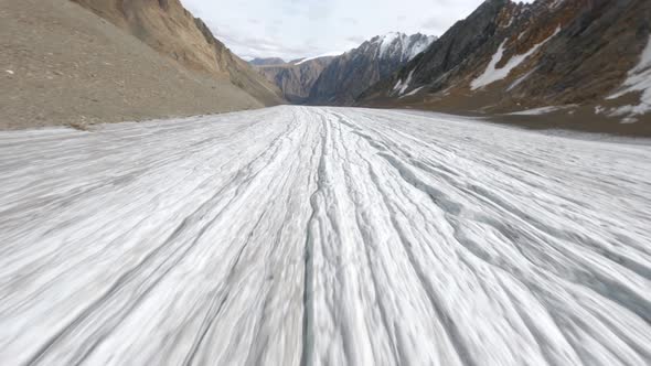 Aerial View Dive Fast Movement Cracked Glacier Snowy Shaky Texture at Picturesque Mountain Valley alt