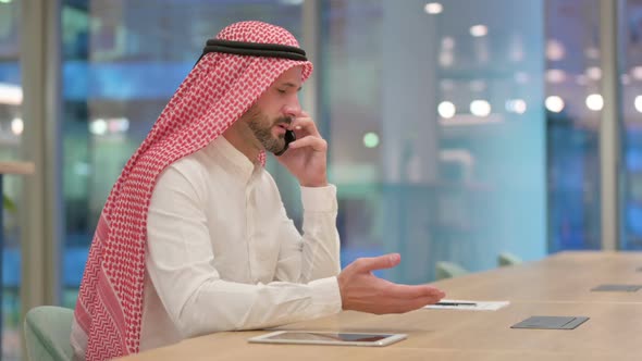 Arab Businessman Celebrating Success on Smartphone alt