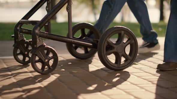 Parent Legs Carriage Wheels Rolling Walkway Closeup alt