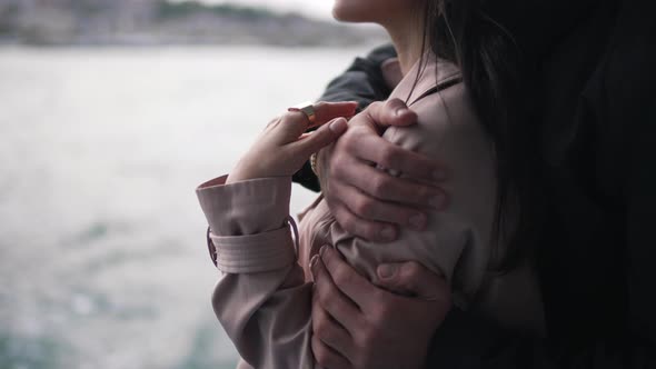 Man Hugging a Girl in a Raincoat Closeup