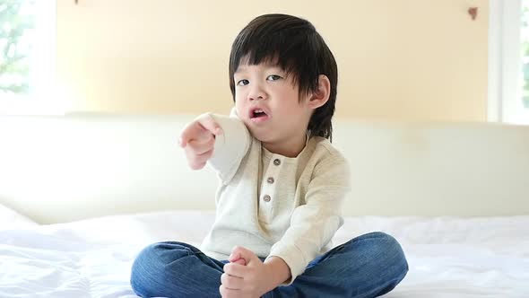 Unhappy Child Sitting On Bed alt