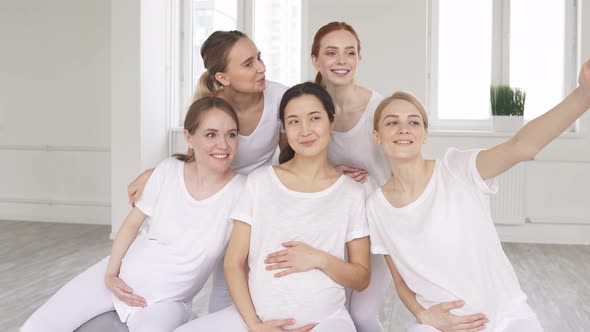 Portrait Of Young Mixed Race Pregnant Women In Sportswear Posing At Camera In Fitness Studio