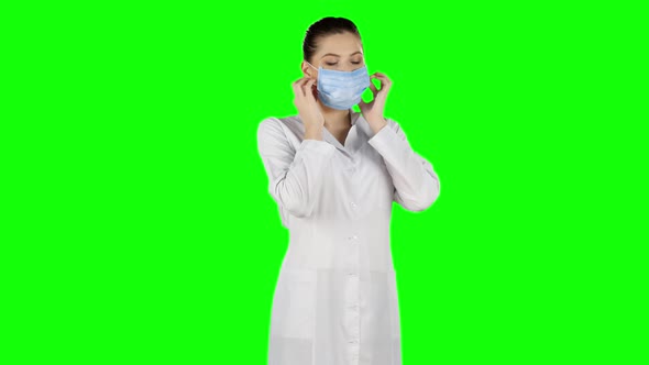 Nurse in Surgery Puts Off the Mask and Smile, Green Screen alt