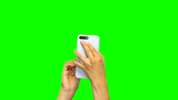 Woman Hands Using White Smartphone. Green Screen Background. Close Up alt