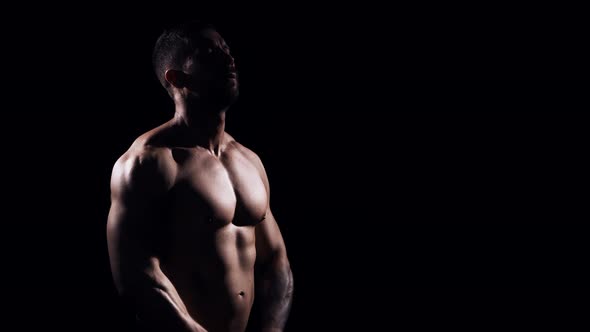 Fit and sporty bodybuilder over black background. alt
