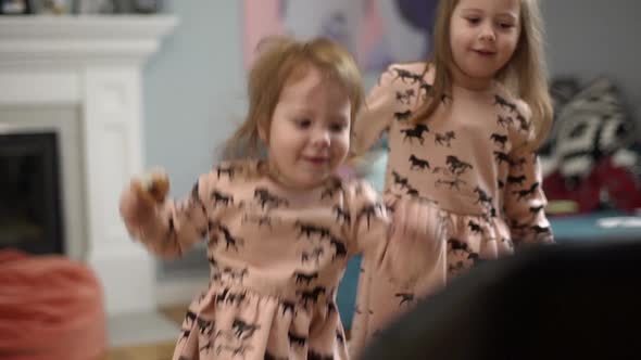 Picture of Beautiful Two Little Children Wearing Dresses Having Fun and Playing Around While Resting alt