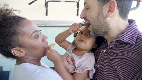 Little girl feeding their parents alt