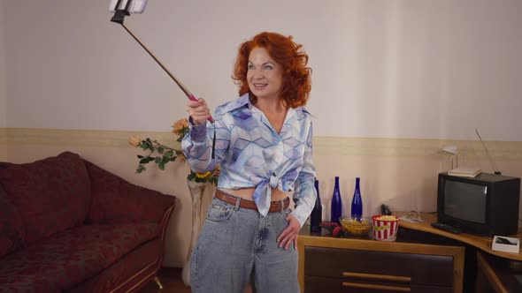 Cheerful Retro Woman Photographing on Smartphone with Selfie Stick in 1990s alt