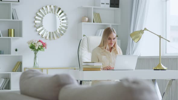 Young attractive woman holding video conference remotely from white room alt