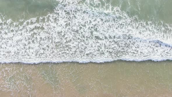 Aerial view drone footage of huge waves crashing on the beach.