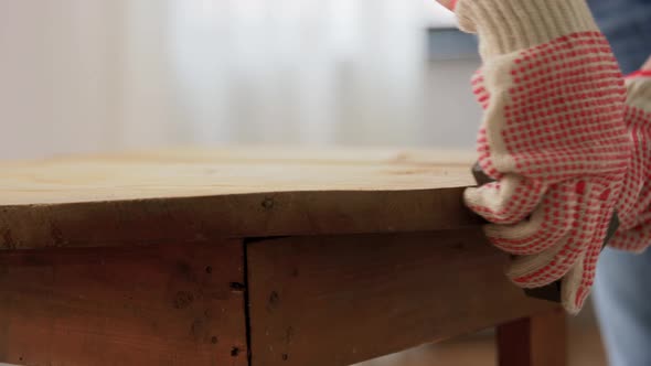 Woman Sanding Old Round Wooden Table with Sponge alt