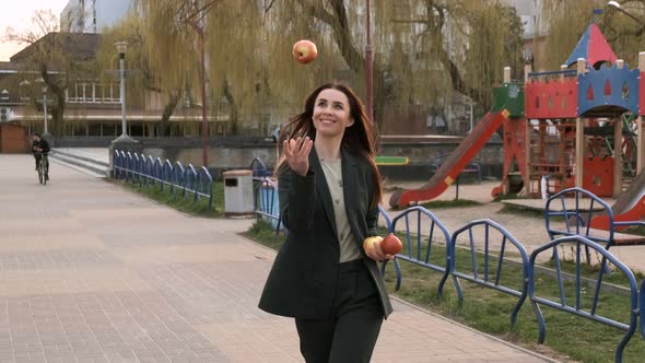 Young attractive woman is throwing apples. Slow motion.