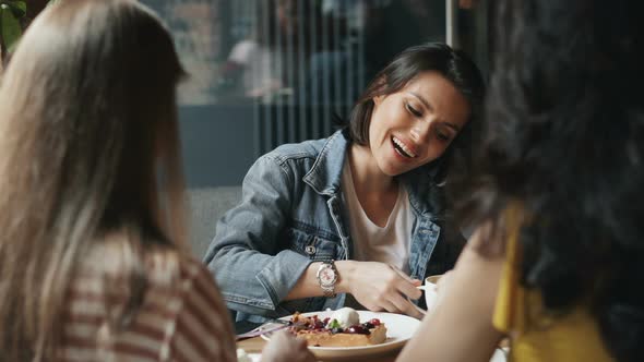 Young Women Eating Desserts and Drinking Coffee in Cafe Talking Having Fun alt