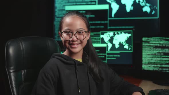 Asian Young Girl Hacker Hacking With Multiple Computer Screens And Smiling To Camera In Dark Room alt