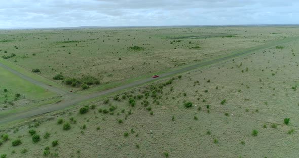 Aerial view of a red car driving on country road