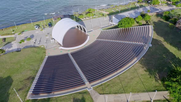 Aerial top down shot of empty amphitheater in Puerto Plata during sunny day and Caribbean Sea in bac alt