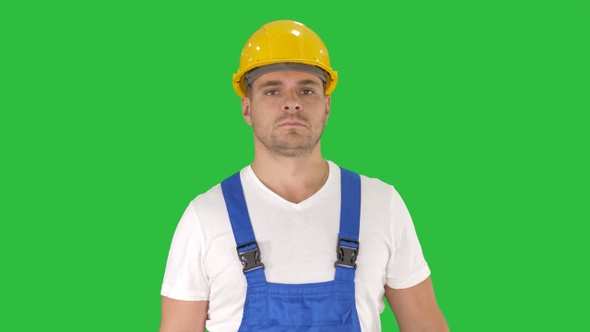Builder walking and looking to camera on a Green Screen alt