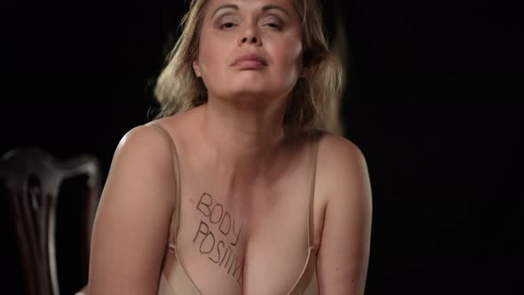 Front View Smiling Plus Size Seductive Woman Tossing Long Hair Showing Body Positive on Chest alt