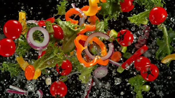Super Slow Motion Shot of Flying Cuts of Colorful Vegetables and Water Drops at 1000Fps. alt