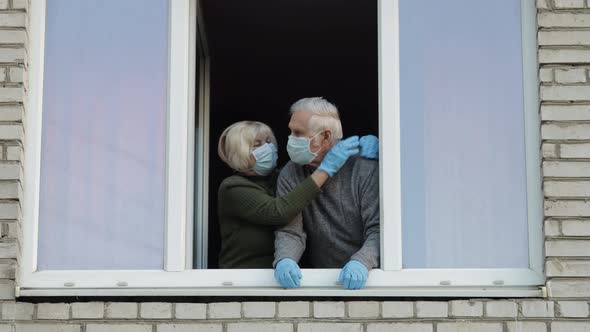 Old Grandparents Stay at Window Isolated at Home on Quarantine. Coronavirus alt