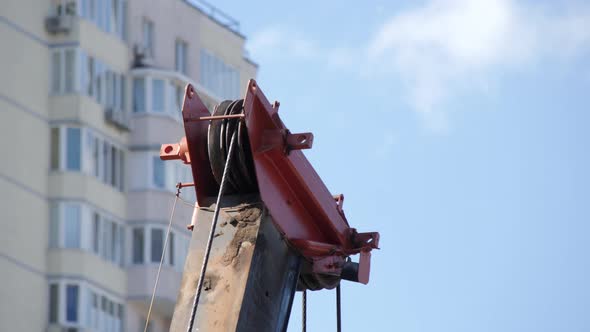 Tower Crane Hoist Rope against the blue sky and new building. Hawser of crane winch.