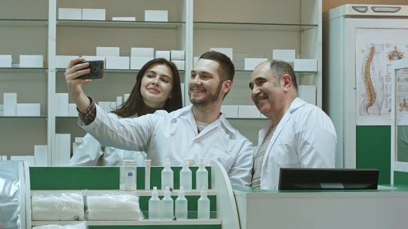 Cheerful team of pharmacist and interns take selfie via