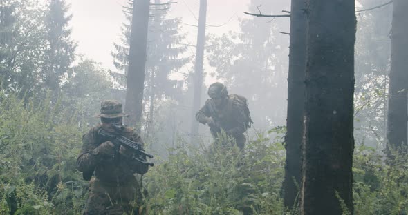 Soldiers in the Smoke Moving in Battle Operation Through Dense Forest alt