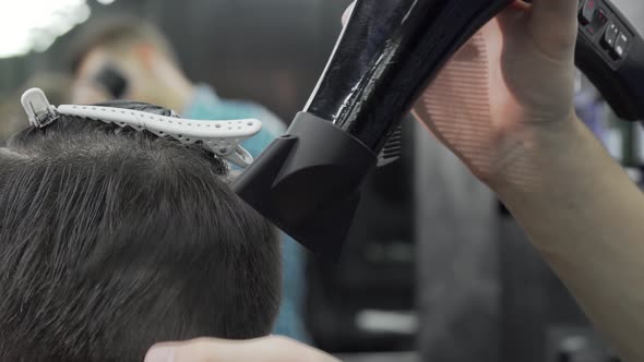 Cropped Shot of a Barber Using Blow Dryer While Styling Hair of a Client