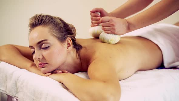 Massage Therapist Using Herbal Compress on Woman alt