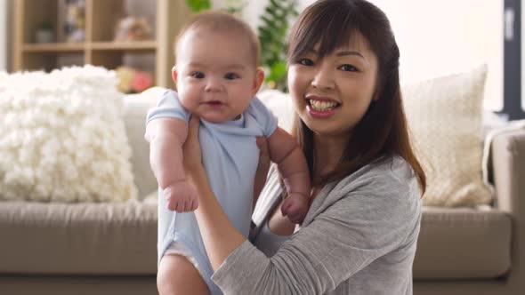 Happy Young Mother with Little Baby at Home alt