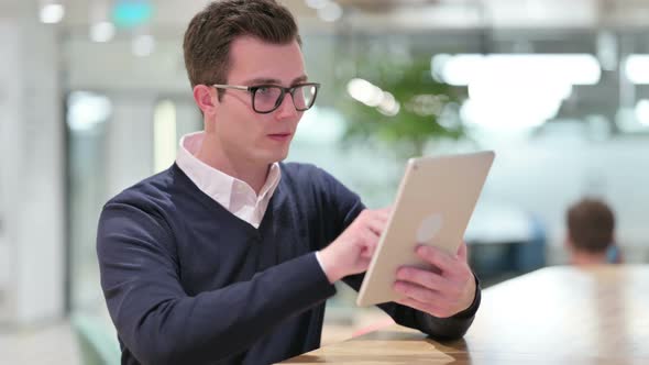 Serious Professional Young Businessman Using Tablet  alt