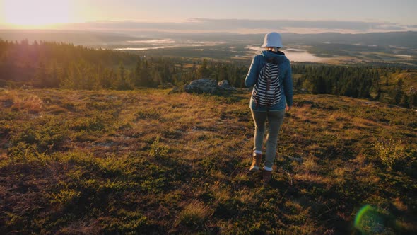 Active Traveler with a Backpack Behind Her Back Walks Through the Picturesque Highlands in Norway alt