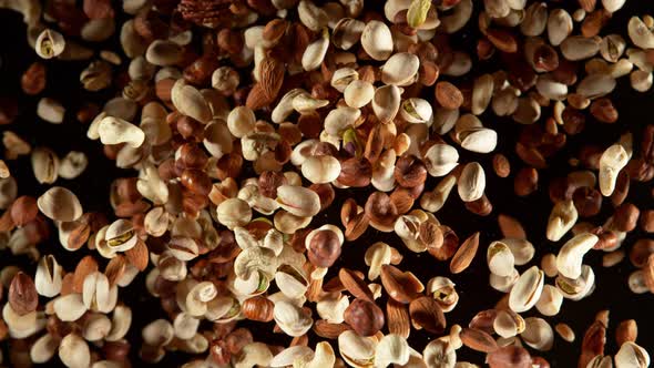 Super Slow Motion Shot of Flying Various Nuts Towards Camera Isolated on Black at 1000Fps alt
