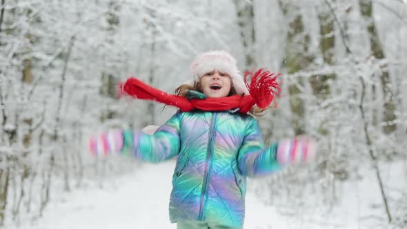 Little Girl Jumping on the Snow Wearing Snow Clothes Play Outdoors in Winter
