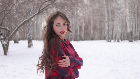 Female in Checkered Shirt Walking in Snowy Park