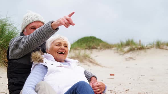 Happy senior couple pointing at view alt