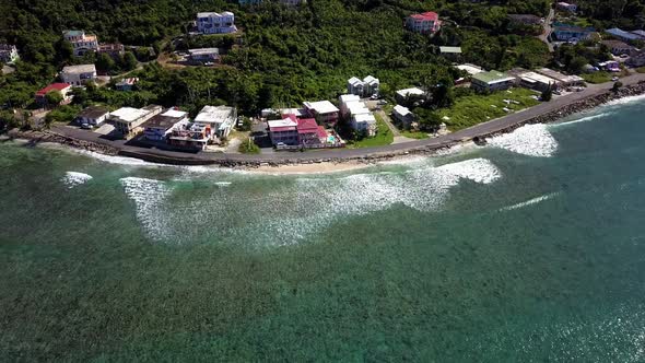 Aerial fly over of local homes on a beach BVI island Tortola. alt