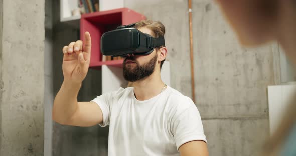 Male in VR Headset Gesturing in Office