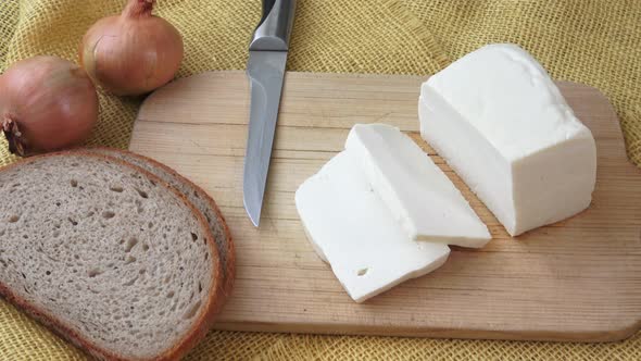 Goat cheese on a wooden cutting board. 