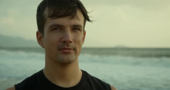 Young Handsome Caucasian Man Looking at the Camera Smiling Against the Backdrop of the Beautiful Sea alt