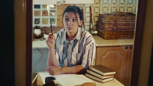 Woman Author Inspired By an Idea Writes a Book Sitting at the Table alt