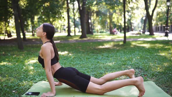 Athletic Young Woman Doing Yoga in the Park in the Morning alt