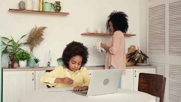 Little Focused Afro American Schoolgirl Studying Remote Online From Home Using Laptop alt