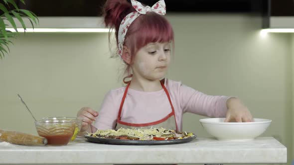 Cooking. Little Child in Apron Adding Grated Cheese To Raw Pizza in Kitchen alt
